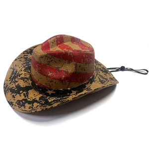 Close-up of straw cowboy hat with hand-painted US flag design and adjustable black cord