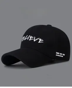 Detail of white embroidered letters on a black twill baseball cap with vintage finish