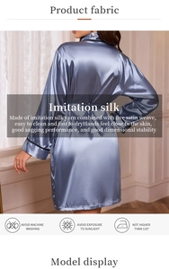 Detail view of smooth dark blue imitation silk bathrobe with black piping and tie waist