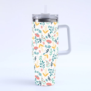 Close-up of 40oz stainless steel tumbler with vibrant floral leaf patterns and straw