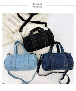 Three denim cylinder crossbody bags in black, light and dark blue with contrast stitching
