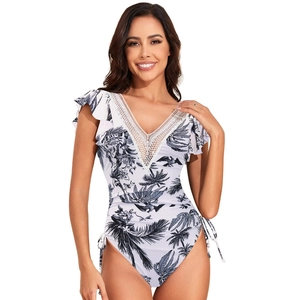 Close-up of V-neck lace patchwork and tropical floral print on a one-piece swimsuit