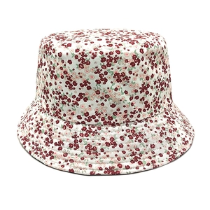 Detail of floral bucket hat featuring red and pink patterns on beige canvas fabric