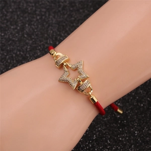 Detailansicht eines roten gewebten Armbands mit einem Sternanhänger und roten Zirkonia