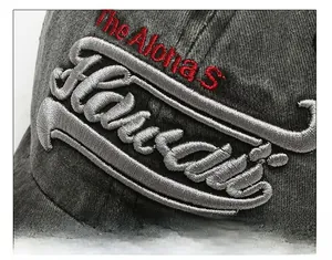 Vue macro de la broderie rouge et grise sur la casquette de baseball en coton délavé