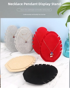 Multiple necklace display stands in velvet and linen textures on a marble table setup