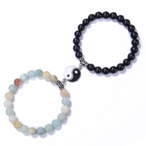 Detail of Yin Yang magnetic couple bracelets with black matte beads and natural stone texture