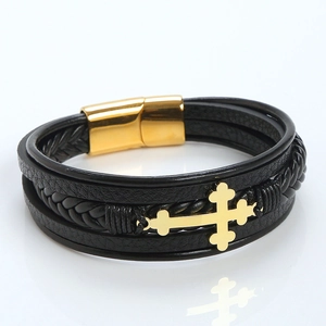 Macro shot of a layered black leather bracelet featuring a gold magnetic clasp and cross