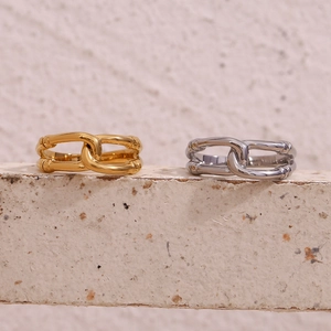 Detailed macro view of gold and silver layered chain link rings on a natural stone base