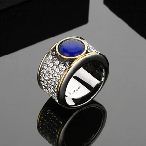 Gros plan d'une bague large pour homme en acier avec œil-de-chat bleu et zircons