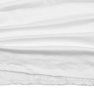 Détail de robe blanche montrant la texture lisse et la bordure en dentelle délicate