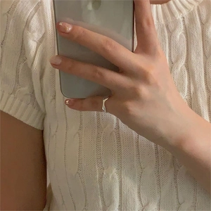 Close-up of a wavy irregular S925 sterling silver ring worn on a model's finger
