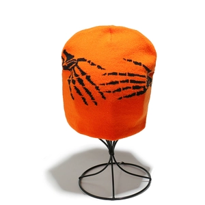 Détail du bonnet en tricot orange avec motif jacquard main de squelette noir pour Halloween