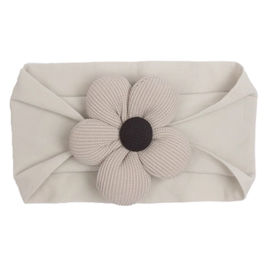 Detail of baby nylon elastic headband with a textured knit beige floral ornament