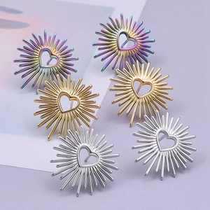 Three pairs of heart-shaped sunburst earrings in rainbow, gold, and silver finishes
