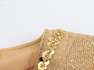 Detail of tweed jacket neckline with gold sequins, rhinestones, and metallic threads