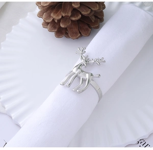 Silver reindeer napkin ring with antlers on a white plate with a pinecone detail