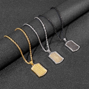 Macro detail of iced out hip hop dog tag pendants in gold silver and black steel