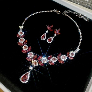 Macro shot of silver-tone floral necklace and earrings with pink crystal drop pendants