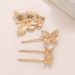 Minimalist gold metal butterfly hair clips set with embossed texture on beige background