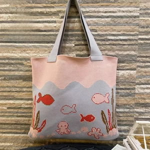 Detail of knitted tote bag featuring colorful octopus and fish patterns with pink handles