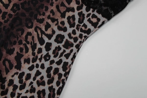 Close-up of brown leopard print fabric with black lace trim detailing on the dress