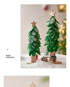 Detail showing two green felt Christmas trees with snow effect and wooden base