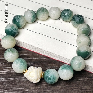 Detailed view of Bodhi root bracelet with carved floral beads and mythical beast charm