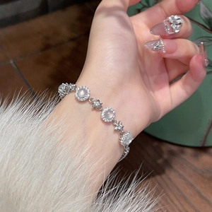 Close-up of silver flower bracelet with zircon stones and chalcedony on a model wrist