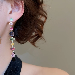 Side view of long silver tassel earrings with colorful zircons on a model