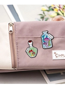 Detail of mushroom enamel pins in glass bottles pinned on a purple canvas bag