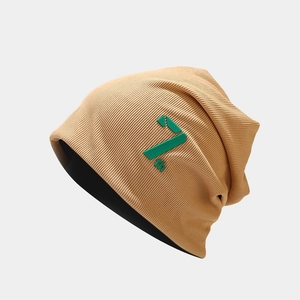 Close-up of khaki knitted beanie featuring green 7th embroidery and ribbed texture detail