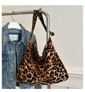 Detail of leopard print canvas crossbody bag featuring a knotted strap design