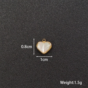 Macro detail of heart-shaped pearl pendant with gold metal edges and size measurements