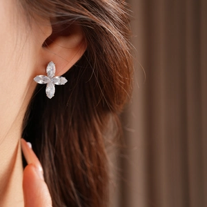 Gros plan de boucles d'oreilles fleur en zircon sur l'oreille d'un mannequin femme