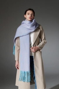 Close-up of soft lavender and sky blue boucle scarf with long fringe details on a model