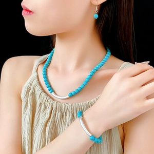 Détail d'une parure en perles de turquoise avec collier bracelet et boucles d'oreilles