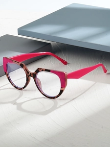 Detail of pink and leopard print cat-eye glasses on a textured minimalist surface