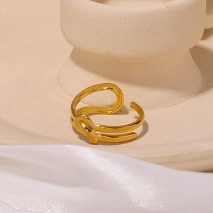 Minimalistischer goldener Knotenhalsring aus Edelstahl auf elegantem Seidenhintergrund