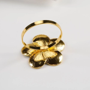 Close-up of golden flower napkin ring with detailed metal texture for wedding decor