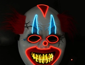 Detail of glow LED creepy clown mask with red blue and yellow cold light lines