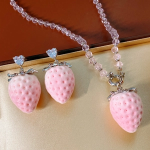 Detail of pink flocked strawberry necklace and earrings with silver heart zircon studs