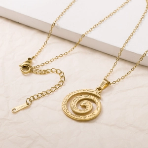 Golden stainless steel swirl pendant necklace with 18K plating on a minimalist stand