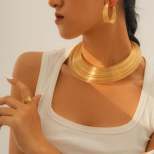 Nahaufnahme von minimalistischem, mehrlagigem Gold-Halskette, Ring und Ohrring Set