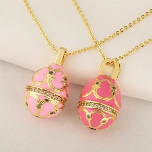 Detail of pink and rose red enamel egg pendants with gold patterns and crystal inlay