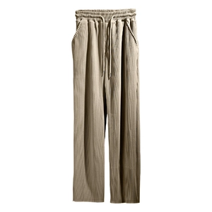 Detail of khaki pleated wide-leg trousers with elastic drawstring waistband and vertical texture