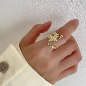 Detail of adjustable gold ring with irregular texture worn with a cream blazer