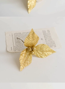 Close-up of golden glitter Christmas leaves with berry accents for holiday wreaths
