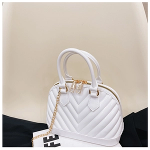 Detail of white jelly shell bag featuring V-shaped embossing and gold chain strap