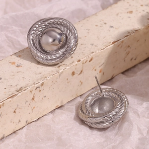 Detailed view of silver twist-textured button earrings with polished metal finish